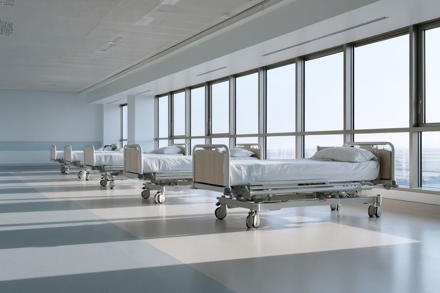 A row of modern hospital beds in a bright ward